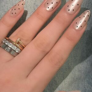 Stylish almond press on nails featuring a cat eye and polka dot design with a nude pink finish.